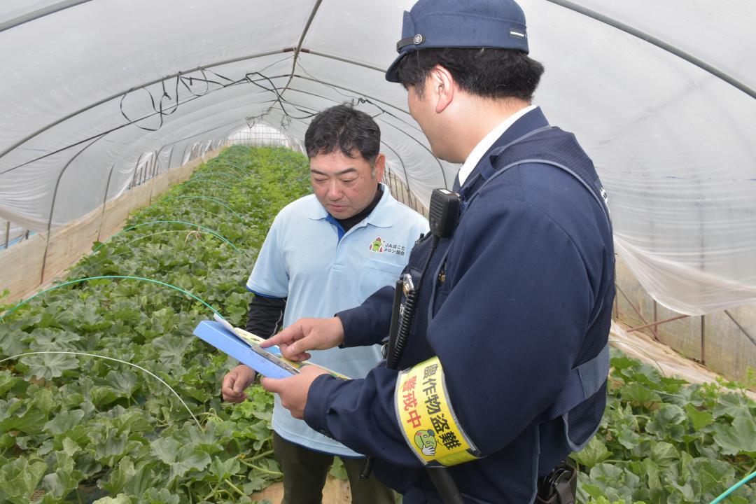 メロン盗難防止のため防犯対策を呼びかける鉾田警察署員=鉾田市内