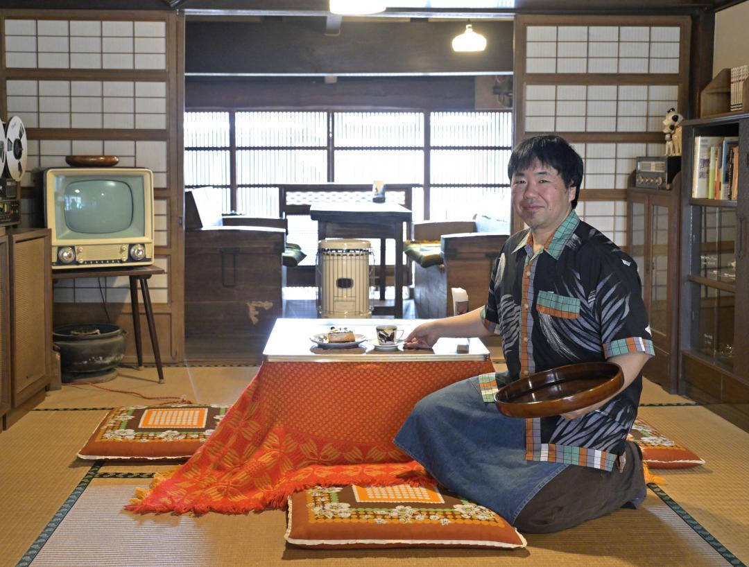 古道具が並ぶ店内で、自家焙煎のコーヒーとデザートを提供する店主の石川昇太さん=常総市豊岡町甲