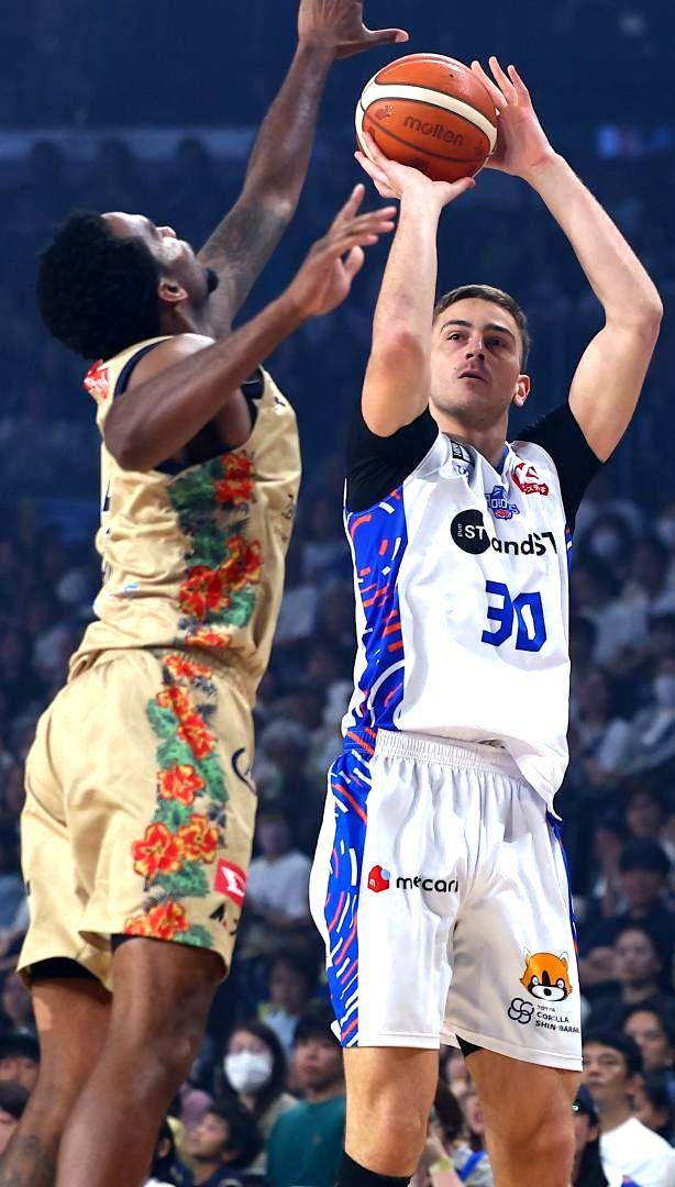 琉球-ロボッツ　第1クオーター、3点シュートを決めるロボッツのシュナイダー(右)=沖縄サントリーアリーナ(©B.LEAGUE)