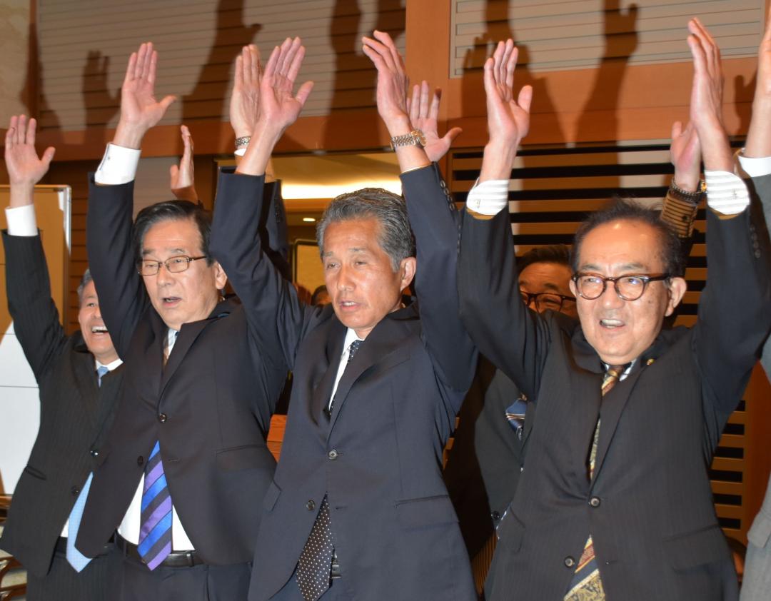 笠間市長選で6回目の当選を決め万歳する山口伸樹氏(中央)＝12日午後8時40分ごろ、笠間市笠間