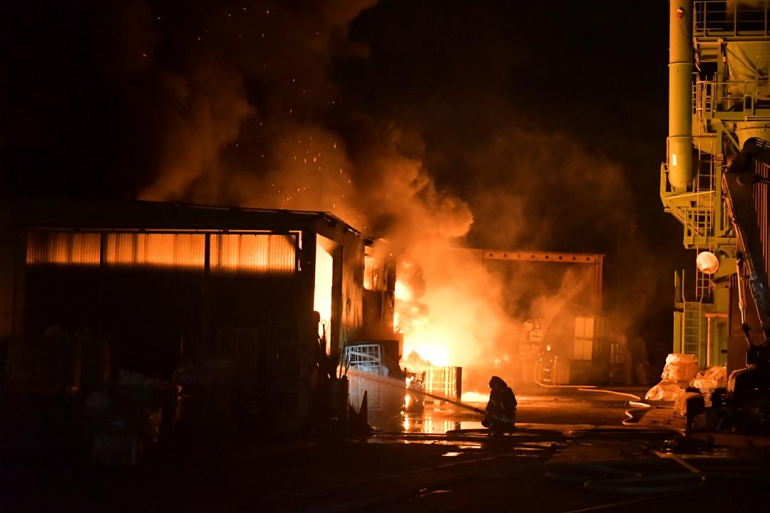 激しい炎が上がる火災現場と消防隊員ら=13日午前1時25分ごろ、茨城町長岡